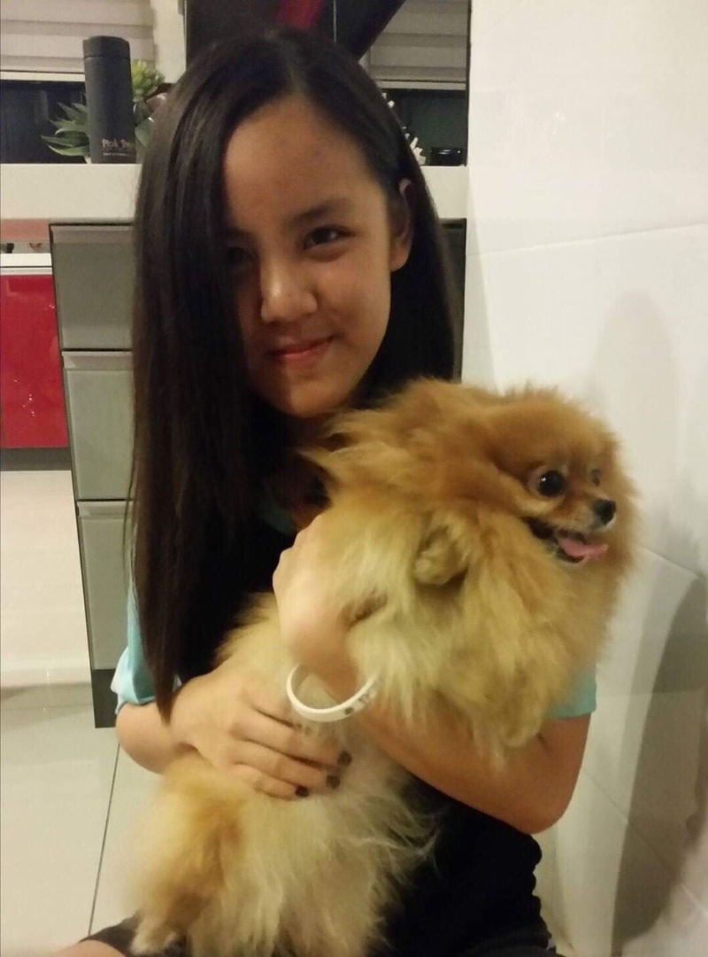 孔怡令在初中一时与宠物狗博美犬合影，以留下做纪念。