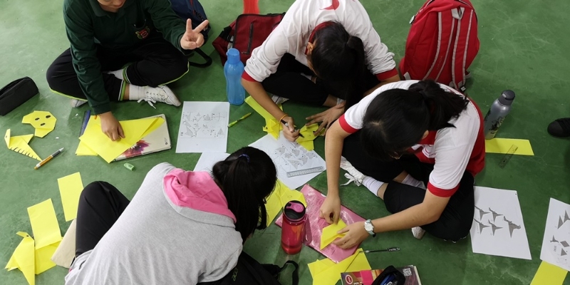 参赛的会员们正在聚精会神地依照说明书，学习“看似简单”的动物折纸。