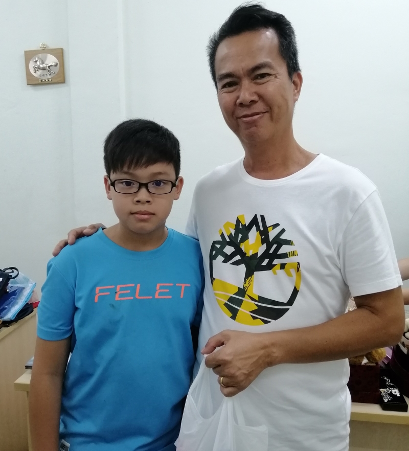 谭博文（左）和父亲一同到来购买旧物，满载而归。