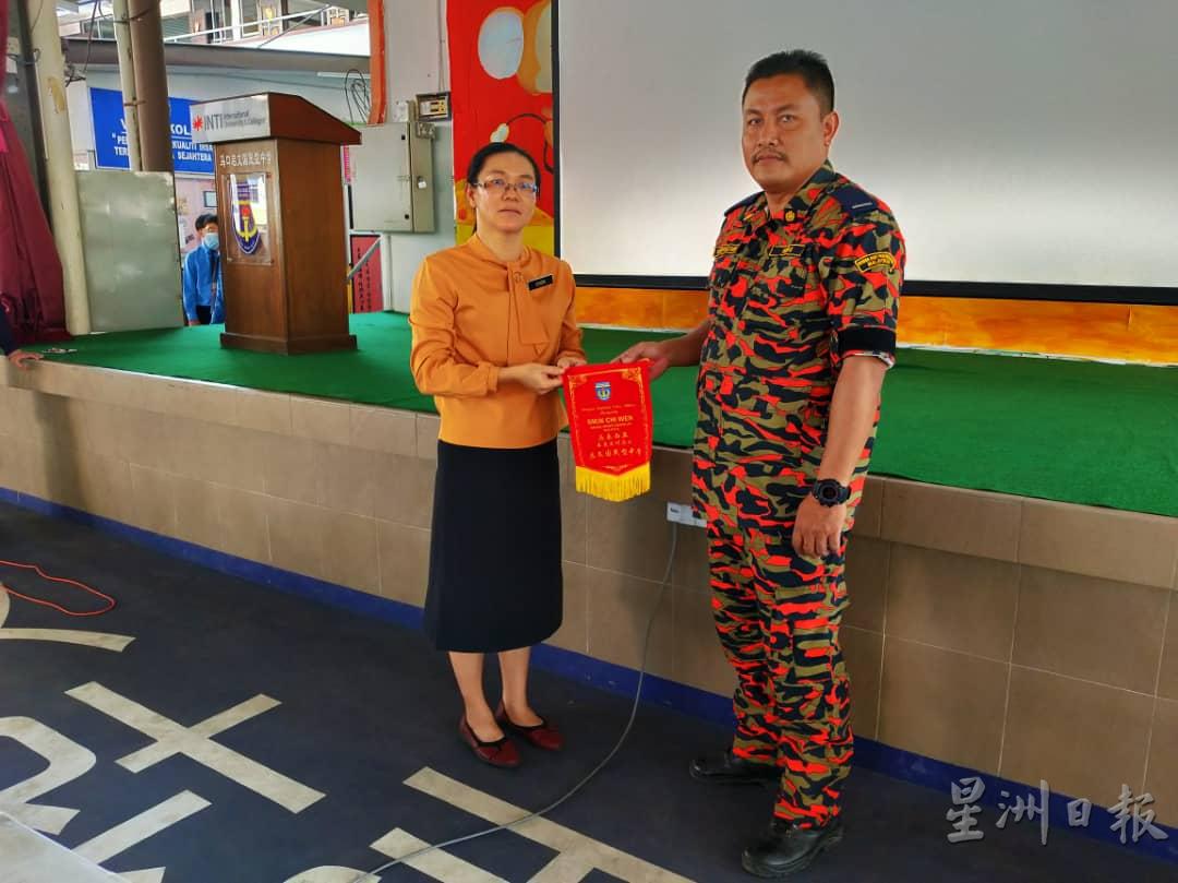 图为该校副校长祝丽蓉（左起）颁发纪念品予马口消拯局官员。