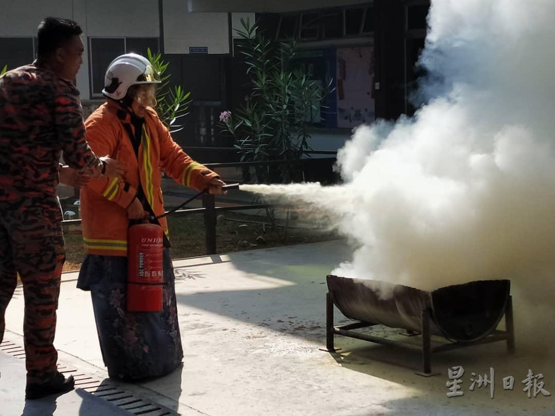 学生周俊伟穿上一身消防服，首次使用灭火器进行灭火，场面惊险又有趣。