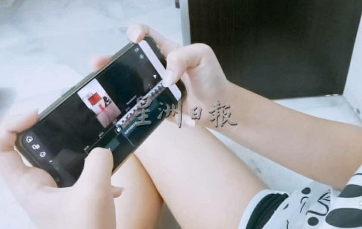 梁忆敏使用手机应用程序，学习剪辑影片。