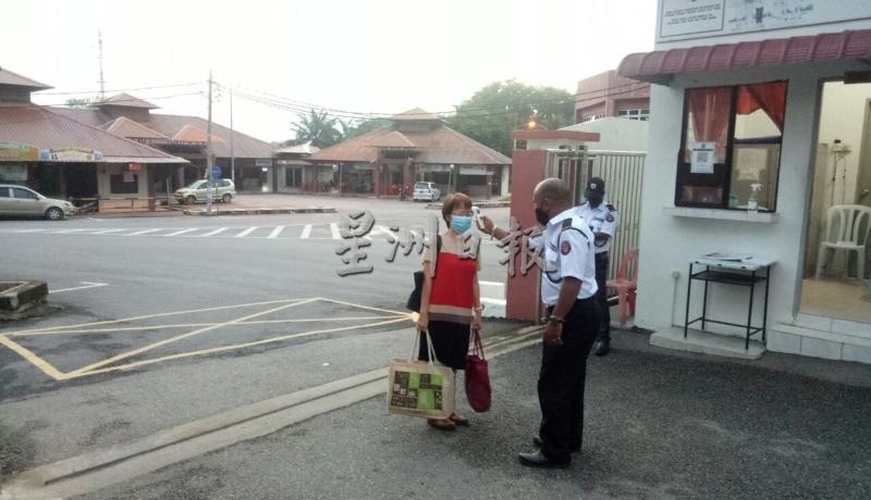 图为启中的保安人员为复工的老师测量体温。
