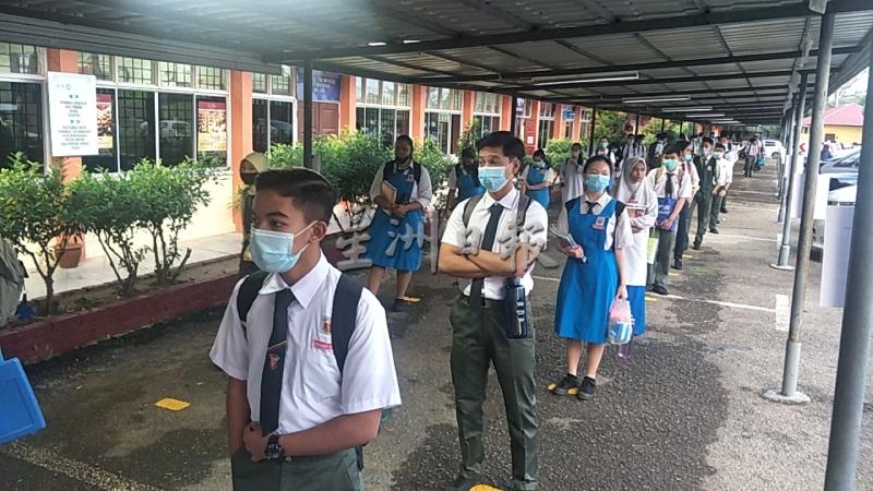 学生在停车棚列队等候时，都有持人身距离。