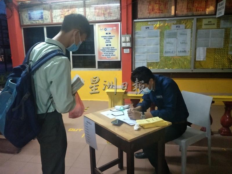 学生在报到处记录体温。