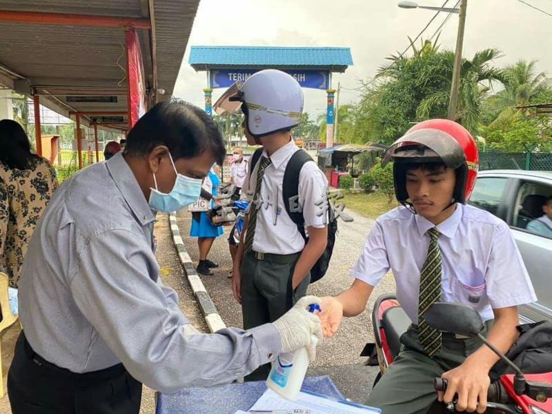 学生进入校园前使用消毒液消毒。