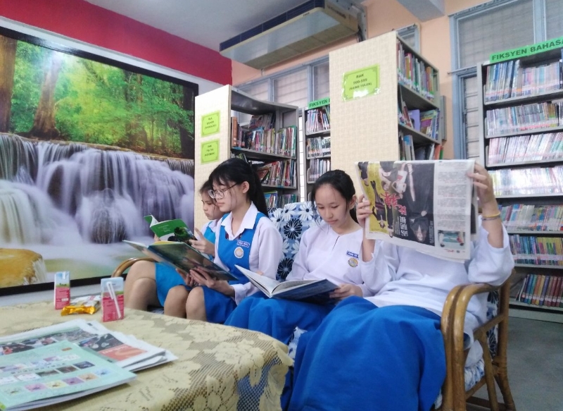 学生们在休闲沙发椅上，阅读图书馆提供的刊物。