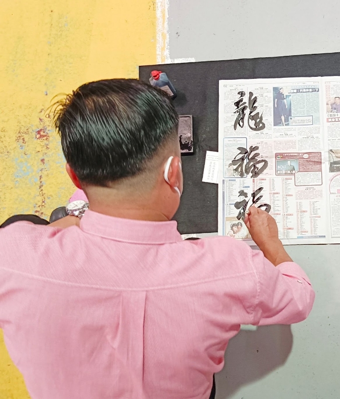 李明辉给参赛者进行简单的书法指导。
