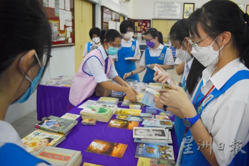 学生们拿起展台上摆放的佛学书籍阅读。