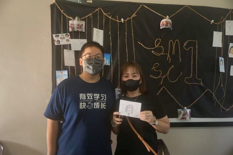 学生在卡片上，画上家长们的图案。
