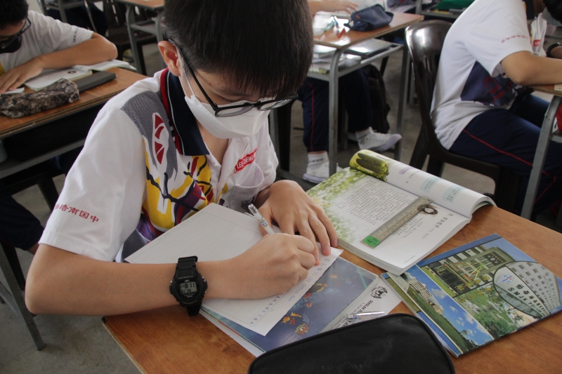 学生正认真抄写文章，争取写出最整齐的字参与比赛。