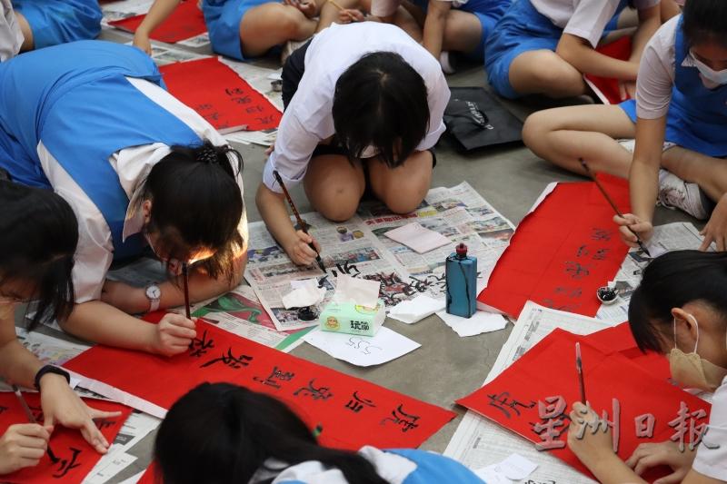 学生们以地当桌，一同写挥春。