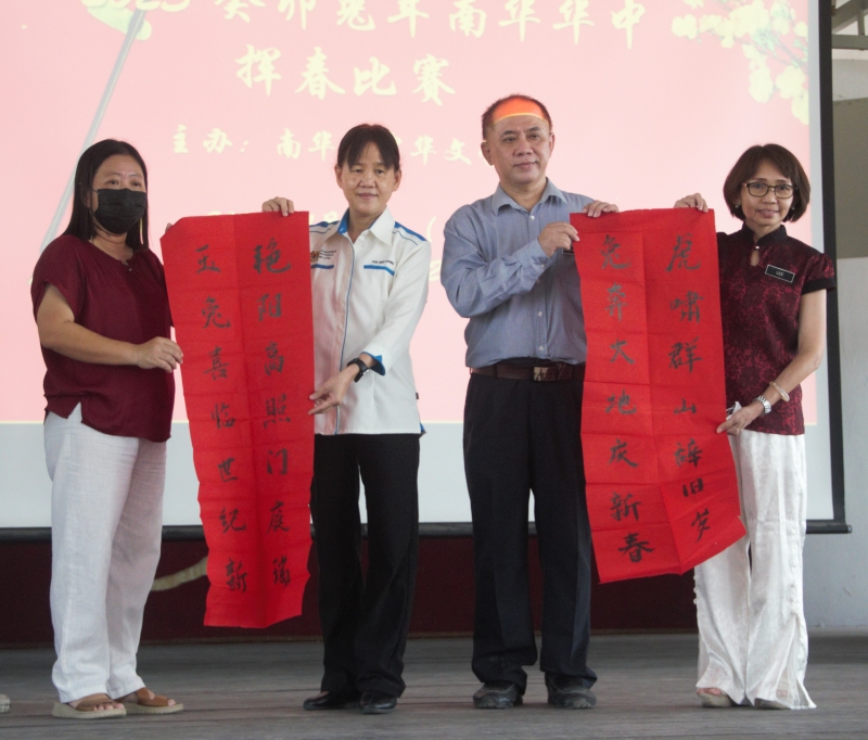 瞿美清（左二）在华文科主任林德盛（右二）以及华文老师汪金芳（左一）和李玉珍（右一）陪同下进行揭封仪式。