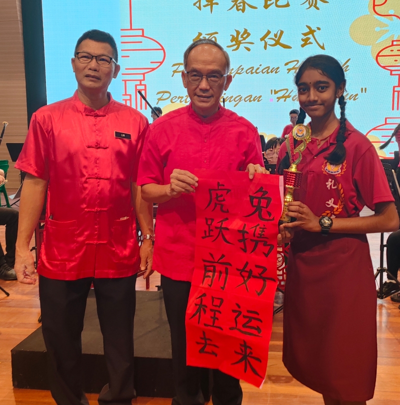 印裔学生彭佳丽（右）荣获书法比赛第二名。左起是林松江、关和贵。