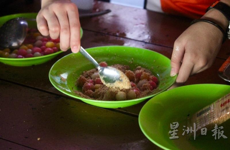 学生把汤圆裹上花生粉，来个不一样吃法。