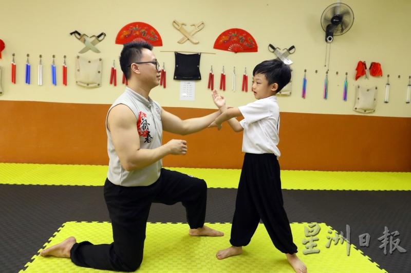 黄文雄（左）指导小学员沈修诚（右）一些基本功。